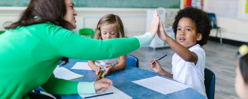 Pädagogin unterrichtet Kinder – Konzeptentwicklung in der Schulkindbetreuung