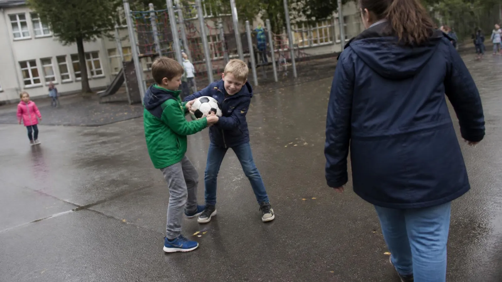Illustration (KI-generiert): Zwei Jungen ziehen auf dem Schulhof am selben Ball, eine Fachkraft kommt dazu